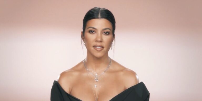 Kourtney Kardashian talking to cameras hair tied back black dress