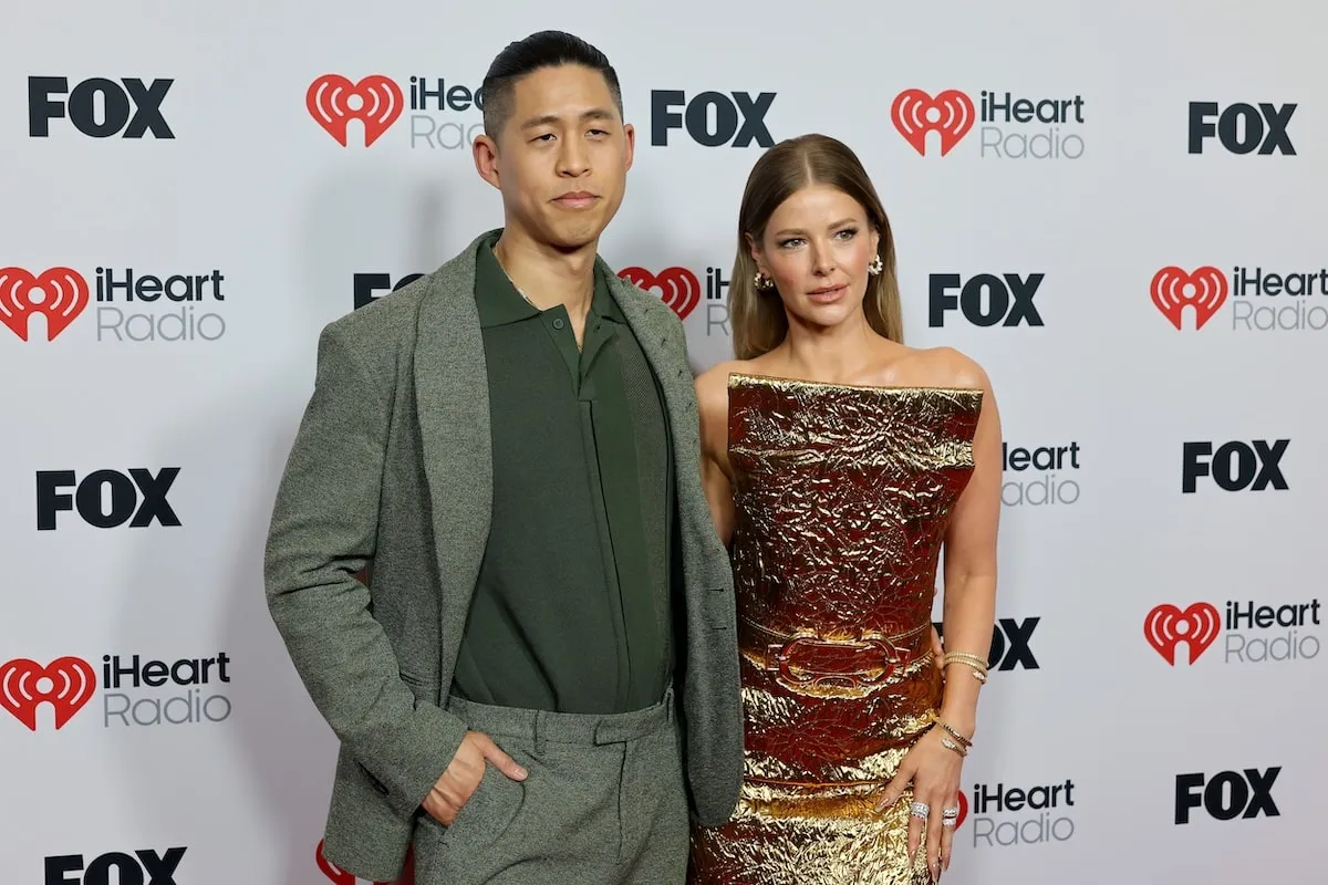 Vêtue d'une combinaison en laine verte et d'une robe en or respectivement, Daniel Wai et Ariana Madix sourient sur le tapis rouge aux Iheartradio Music Awards